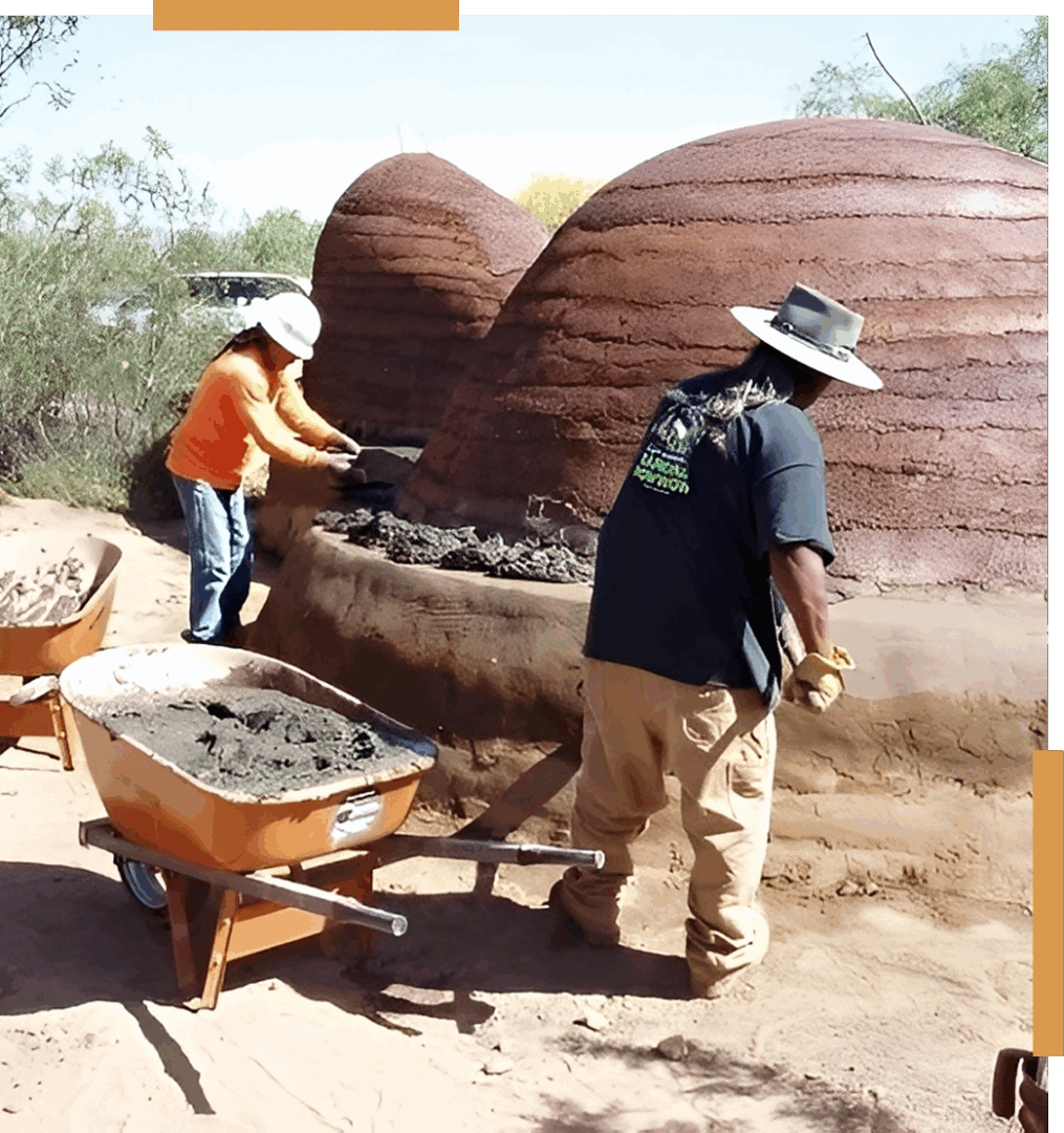 People building with earthbags and wheelbarrows.